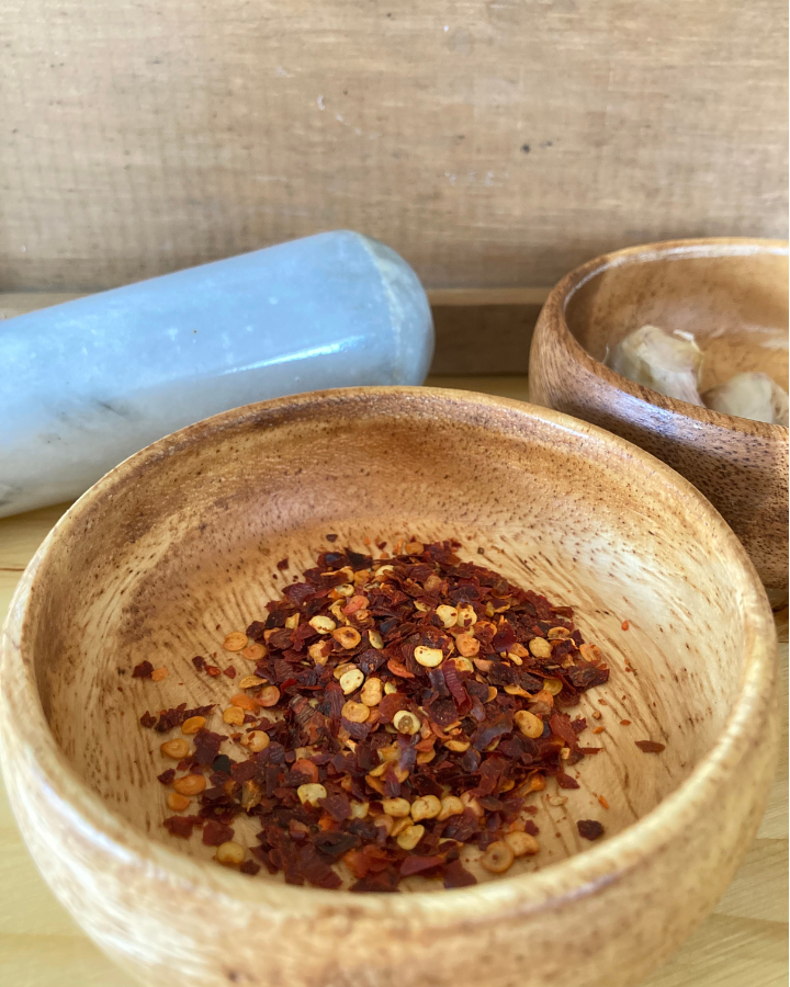red pepper flakes in a wooden bowl