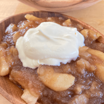 homemade apple pie filling in a bowl with whipped cream
