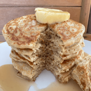 a stack of oat flour pancakes with butter and syrup