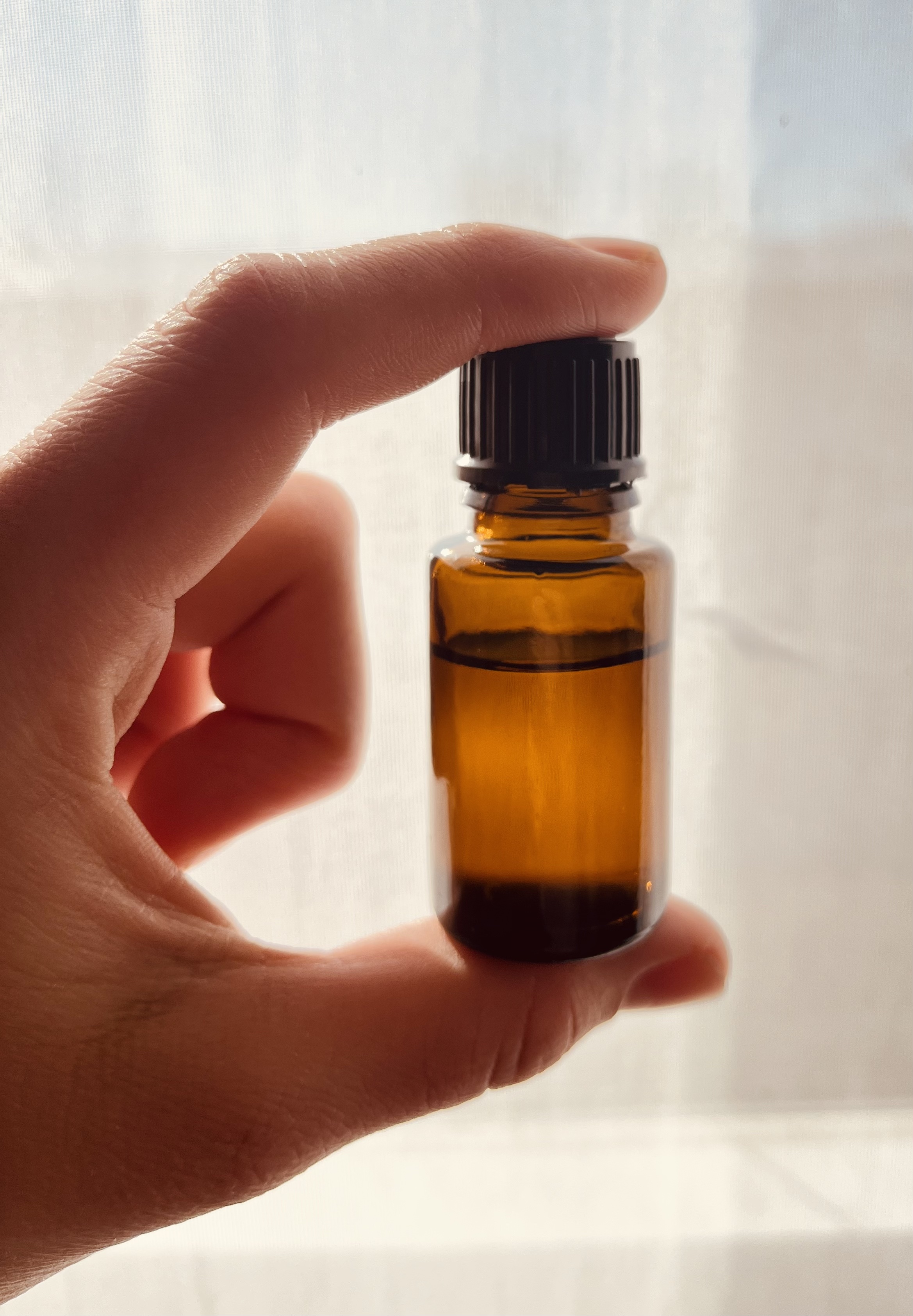 a lady holding a bottle of lemongrass essential oils