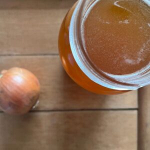 a jaw of honey next to an onion